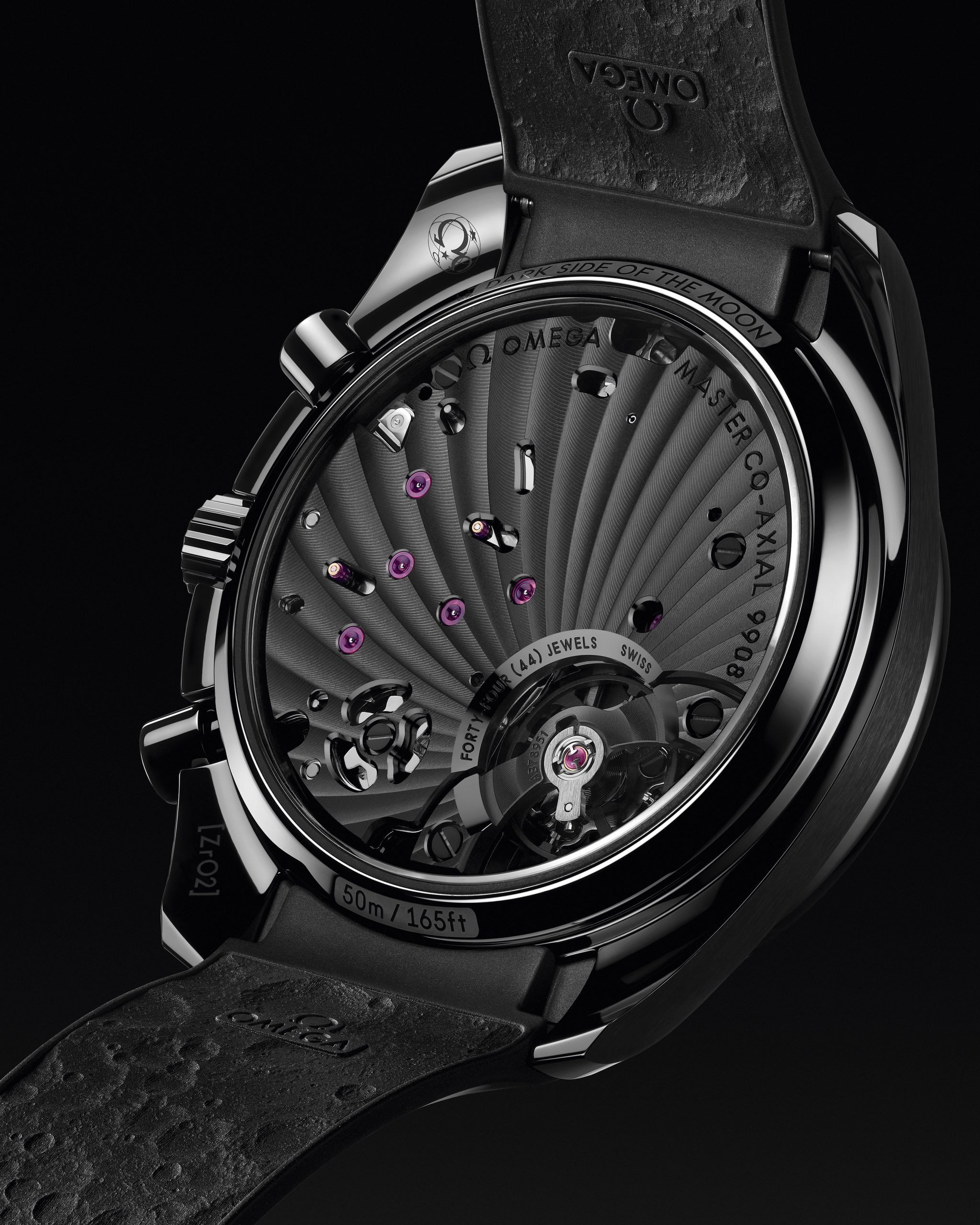 錶背透視9908亮黑版Co-Axial Master Chronometer手動機芯。機芯提供時間顯示和計時功能，動力儲備60小時。主夾板和橋板經過黑色霧面處理和黑色漆面鐫刻，集中視覺焦點於擺輪運轉。