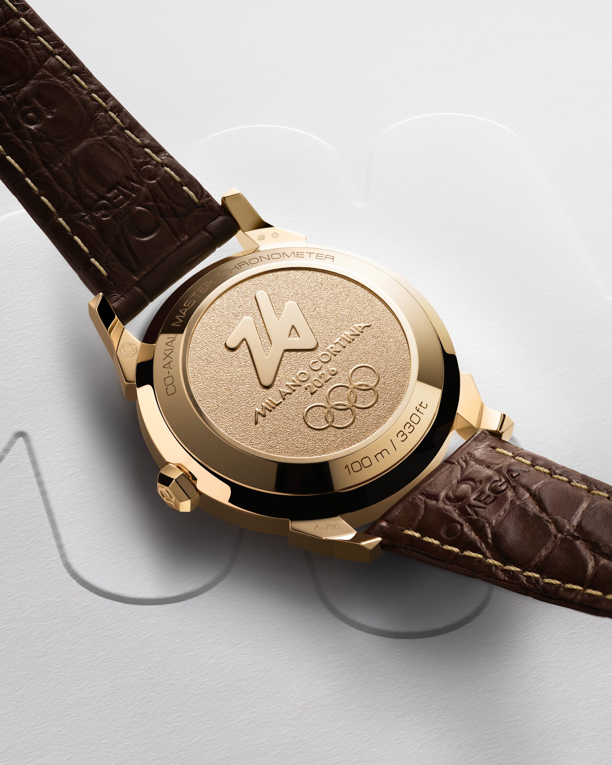 錶殼配18K金密封底蓋飾有2026年冬季奧運會標誌。連同皮革錶帶和金質帶扣，整體融合復古正裝腕錶外觀和現代性能。PHOTO/ OMEGA