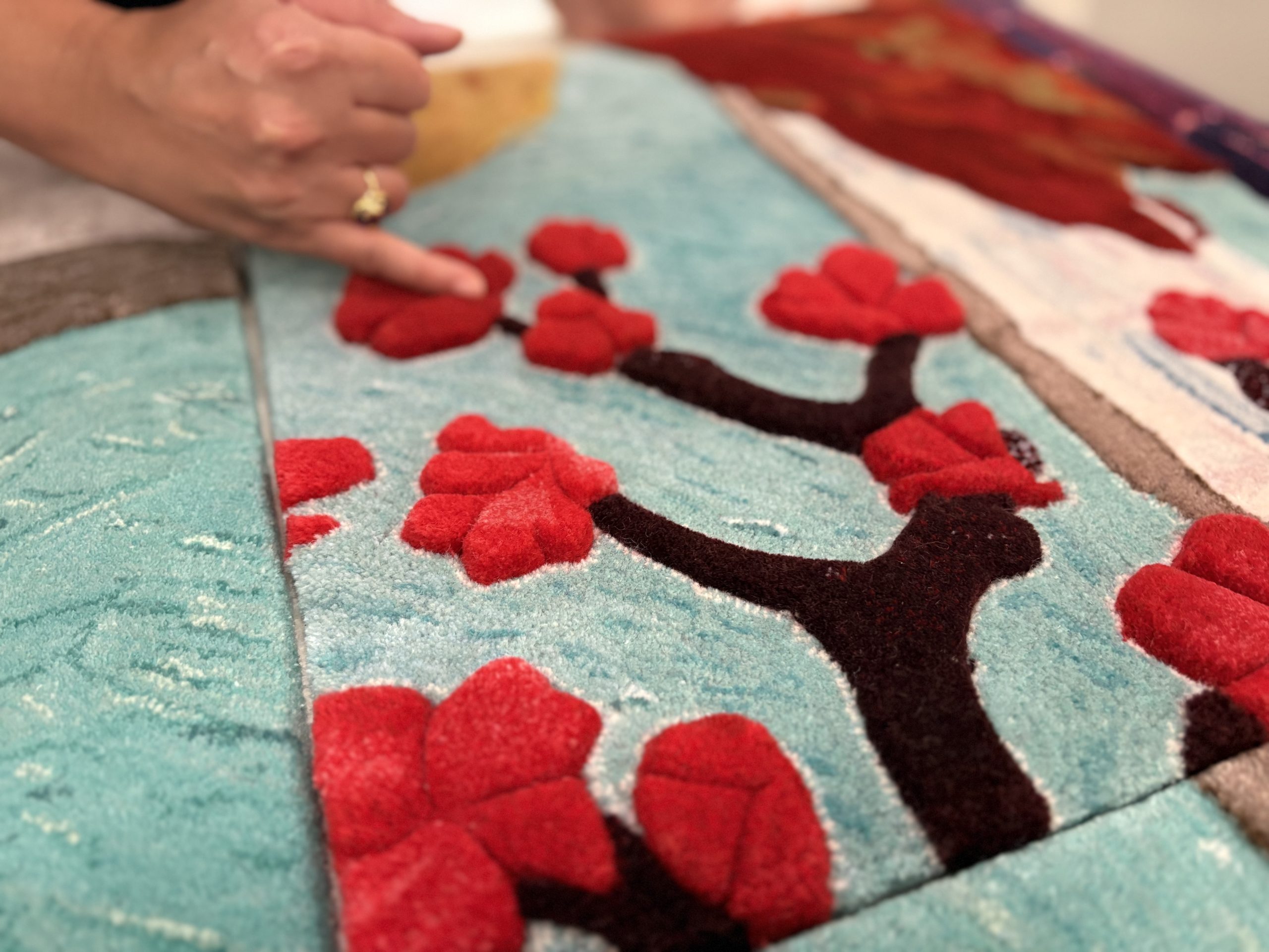 作品由太平地氈工藝師製作的無縫格紋地毯與大型手織牆毯，透過精準的色彩配對與簇絨高度的變化，重塑了原畫的奇幻世界。PHOTO / The Peninsula Hong Kong