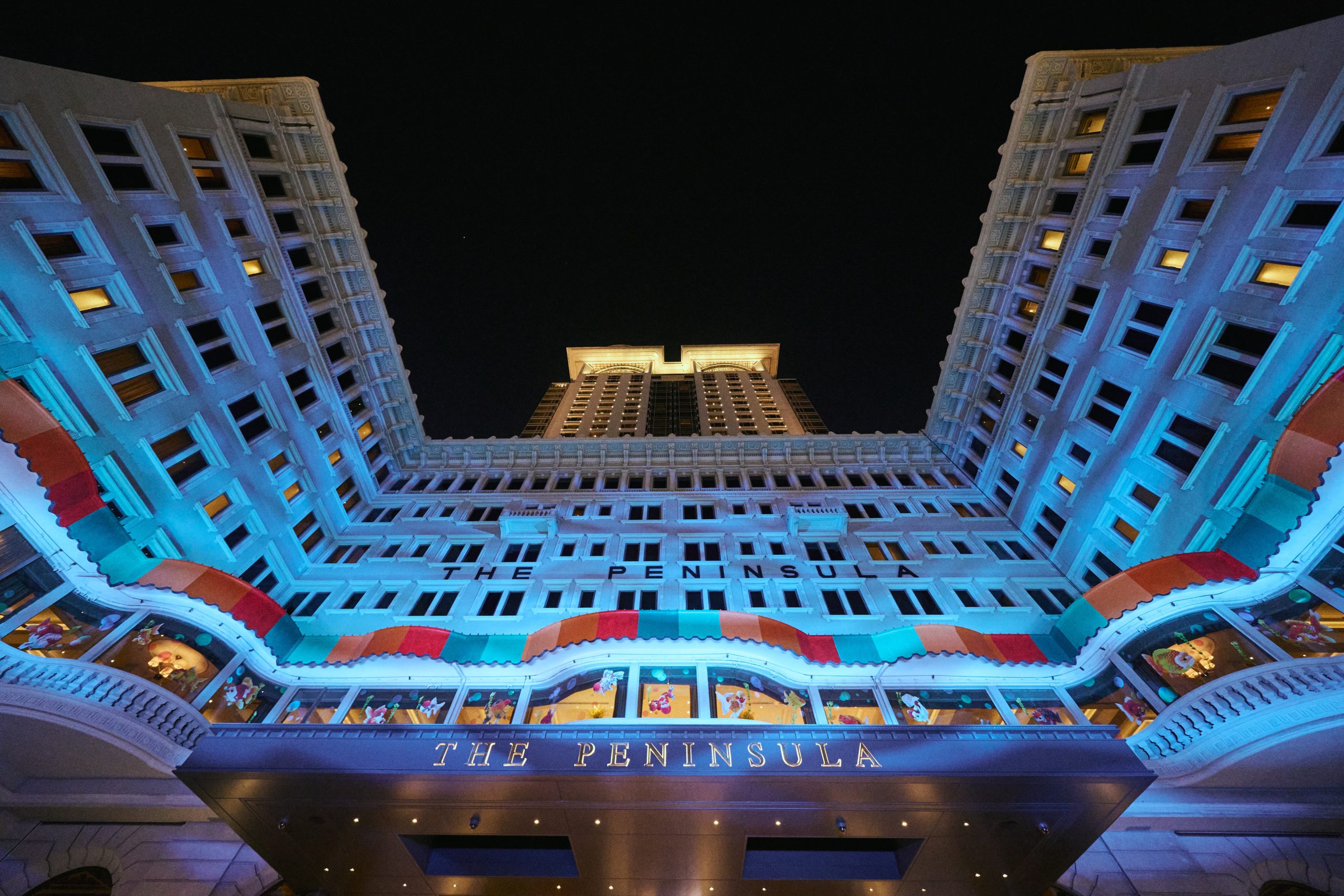 在委約作品《粼光遊樂場》中，Angel將其標誌性的金魚刺繡圖案延伸至酒店外牆、窗戶，以至停泊於門外的勞斯萊斯車身，讓室內外的觀眾均能細意欣賞。PHOTO / The Peninsula Hong Kong