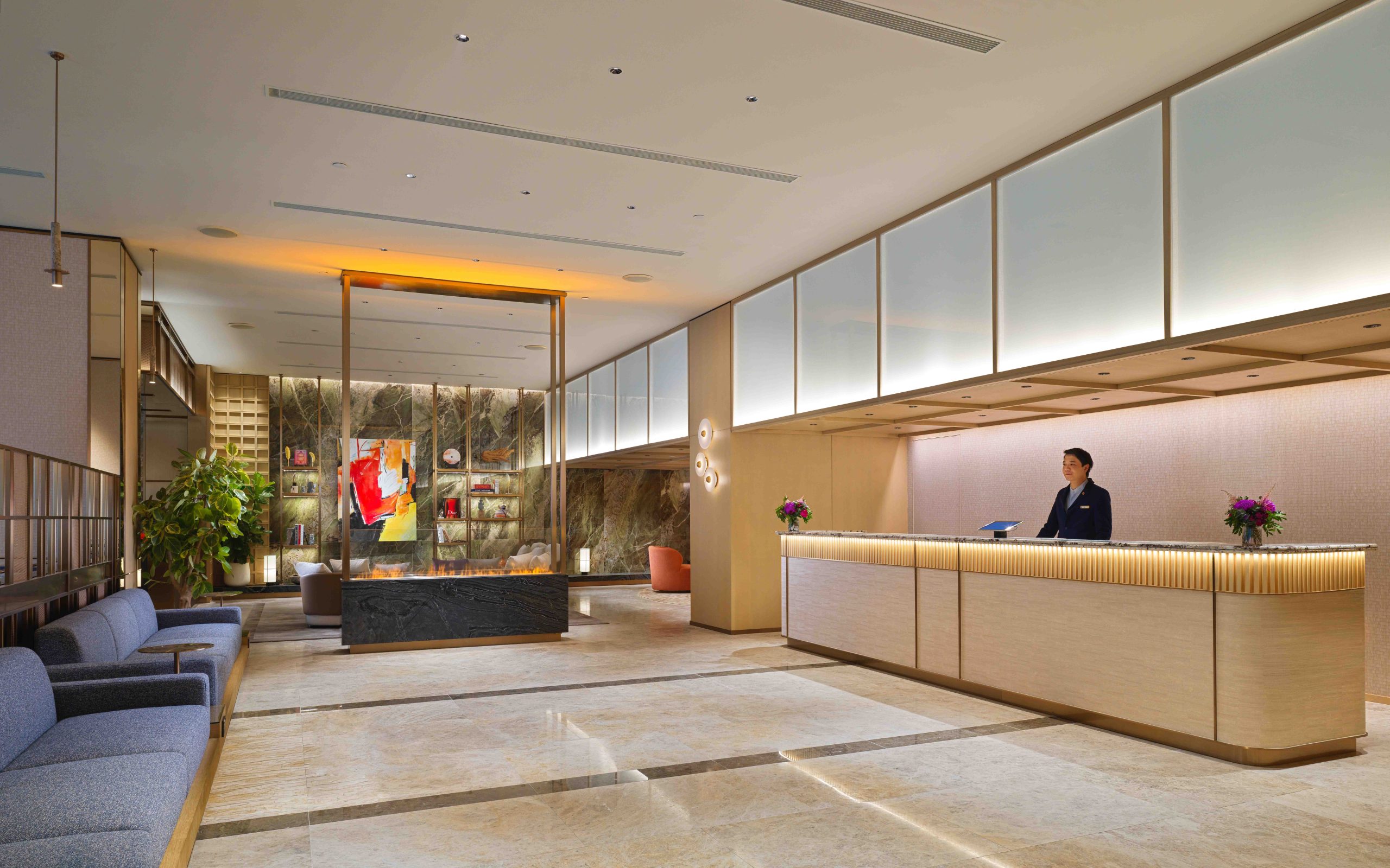 透過天然木材、溫潤雲石與柔和燈光，為全新酒店大堂營造出精緻格調；開放式佈局亦巧妙貫通了接待區與共享空間，擺脫傳統酒店大堂的過渡性質。PHOTO / Nina Hotel Island South